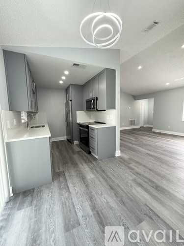 A modern kitchen with a grey cabinetry and a white fridge.
