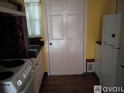 A kitchen with a white door and a white fridge.