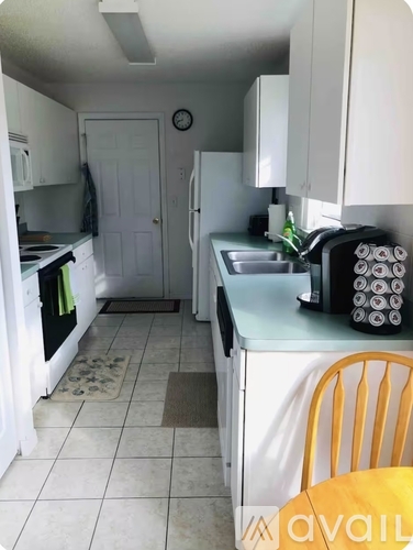 A kitchen with white cabinets and a white fridge.