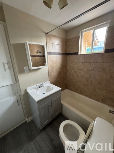 A bathroom with a toilet, sink, and bathtub.