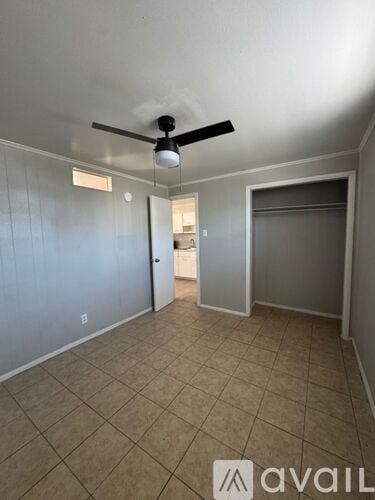 A room with a ceiling fan and tiled floor.