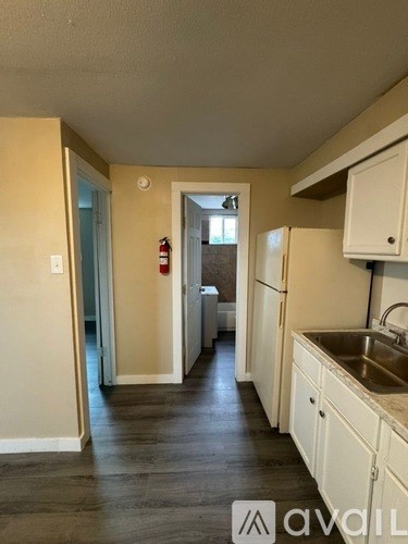 A kitchen with white cabinets and a stainless steel sink.