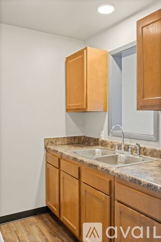 A kitchen with wooden cabinets and a granite countertop.