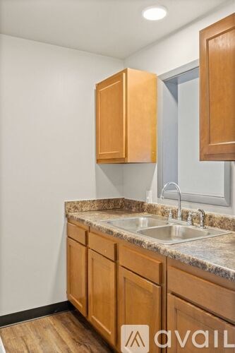 A kitchen with wooden cabinets and a granite countertop.