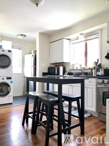 A kitchen with a black table and chairs.