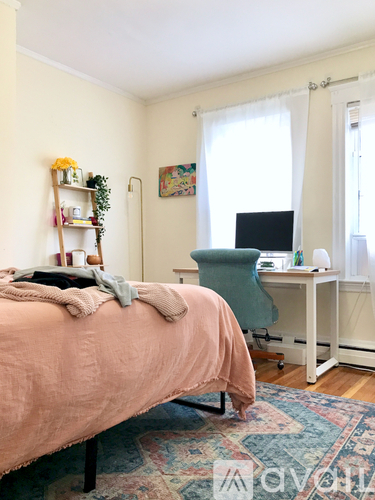 A bedroom with a bed, desk, and chair.