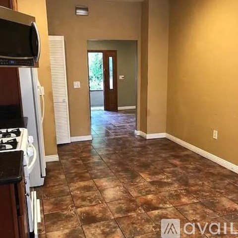 A kitchen area with a stove and a television.