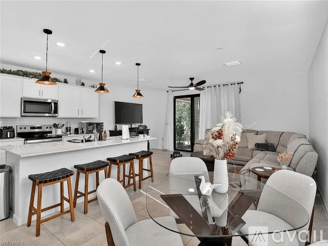 A modern kitchen with a bar area and a dining table set up.