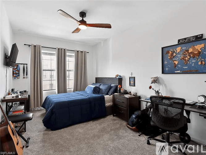 A bedroom with a bed, desk, and chair.