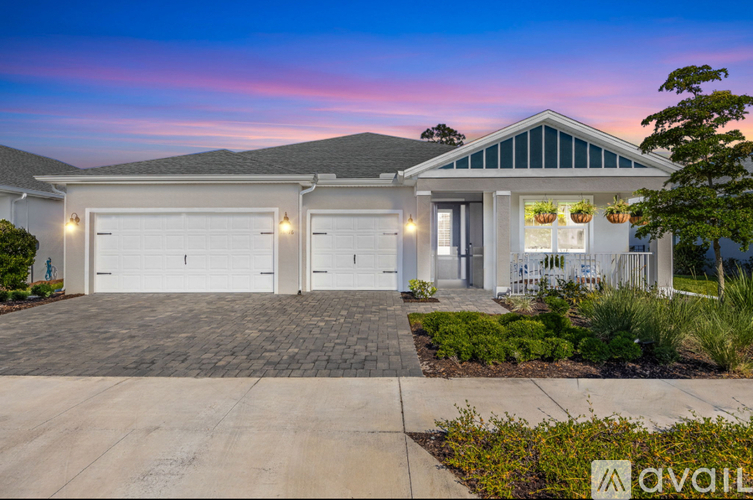 A house with a garage and a driveway in front of it.