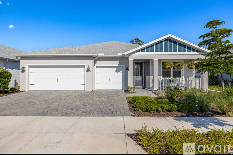 A house with a grey roof and a white garage door.