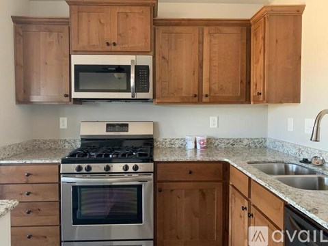 A kitchen with wooden cabinets and a granite countertop.