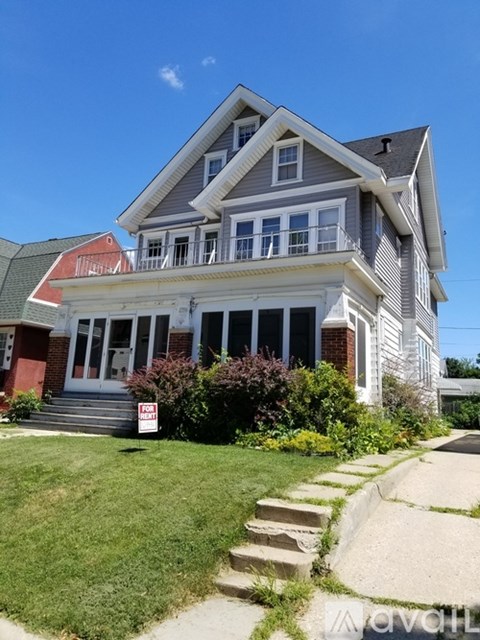 A house with a red roof and a sign that says "For Sale".