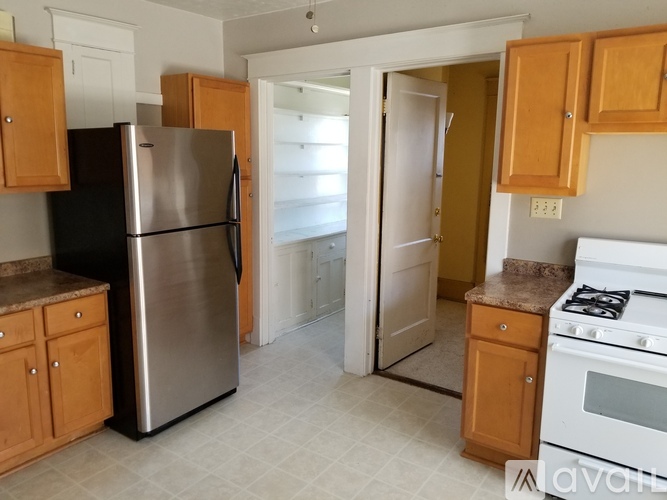 A kitchen with a stainless steel refrigerator and a white stove top oven.