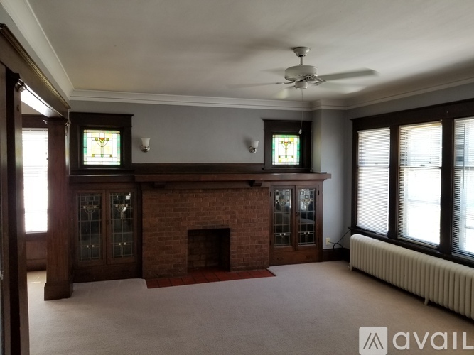 A living room with a fireplace and a ceiling fan.