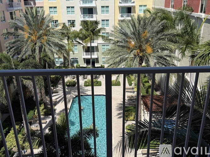 A pool surrounded by palm trees and apartment buildings.