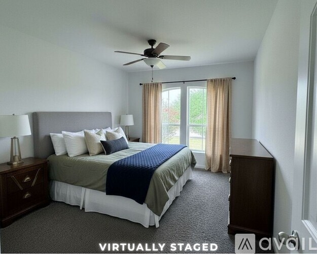 A bedroom with a bed, nightstand, and window.