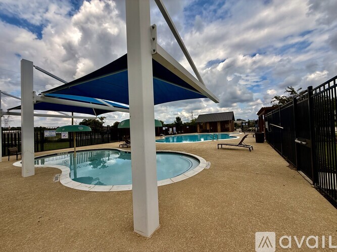 A pool area with a blue canopy and a hot tub.