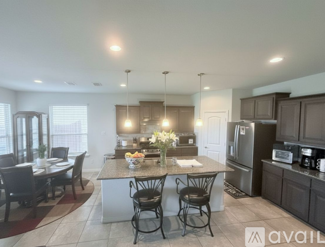 A kitchen with a table and chairs in the middle of the room.