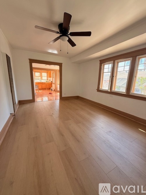 A room with wooden flooring and a ceiling fan.