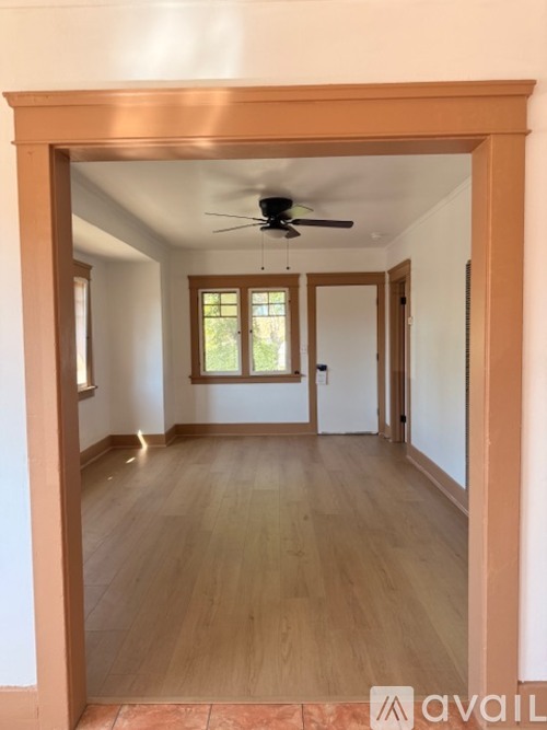 A room with wooden floors and a ceiling fan.