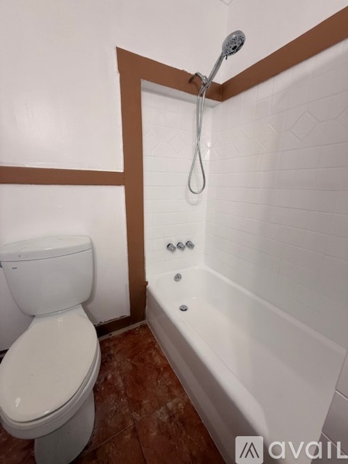 A white toilet sits next to a white bathtub in a bathroom.