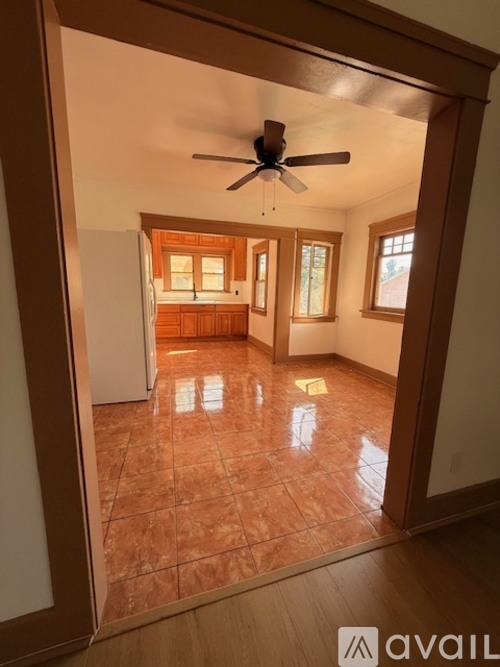 A room with a ceiling fan and tiled flooring.