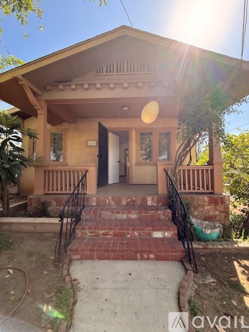 A house with a front porch and stairs leading up to the entrance.