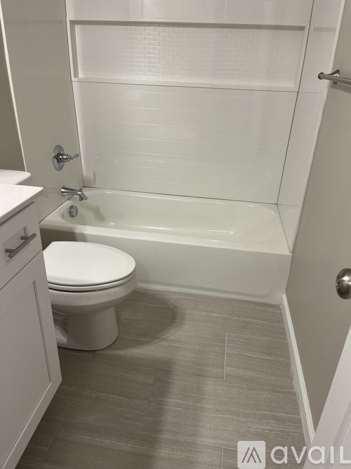 A white toilet sits next to a bathtub in a bathroom.