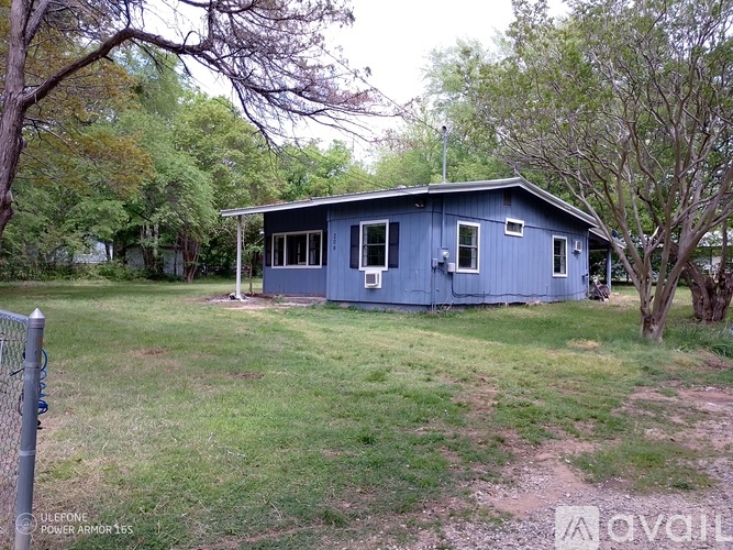 A blue house with a fence in front of it.