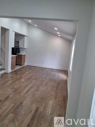 A room with wooden flooring and white walls.