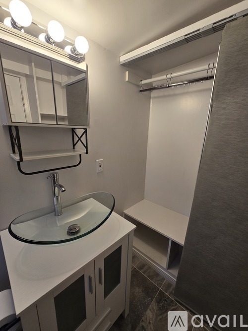 A bathroom with a sink, mirror, and shower.
