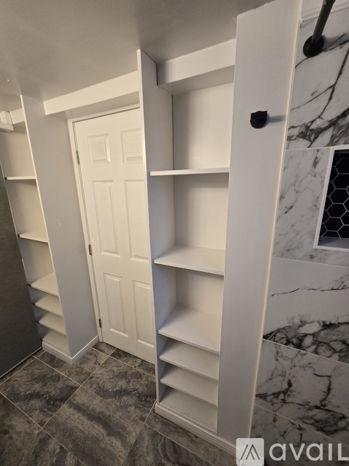 A white closet with shelves and a door.