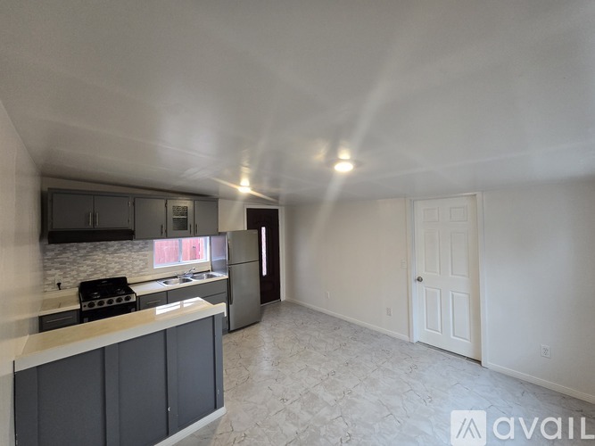 A kitchen with a counter and cabinets is available for rent.