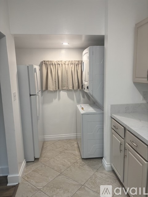 A kitchen with a white refrigerator and cabinets.