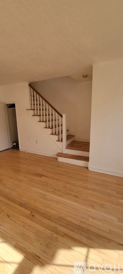 A room with wooden floors and a staircase.
