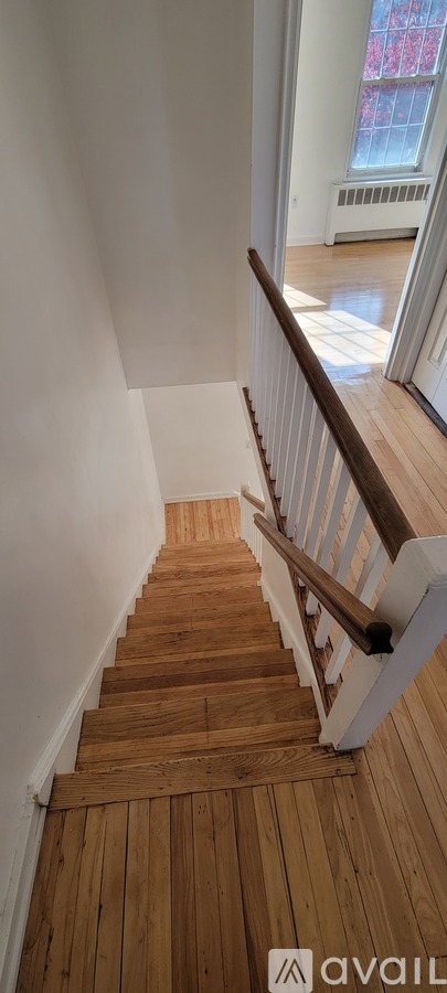 A wooden staircase with a white railing.