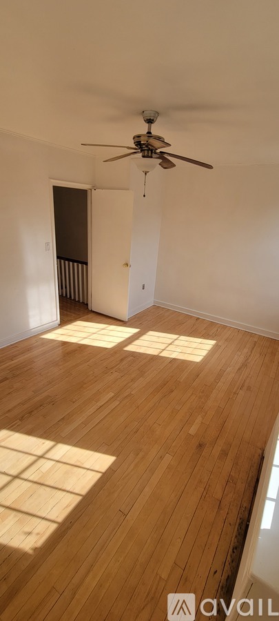 A room with wooden floors and a ceiling fan.