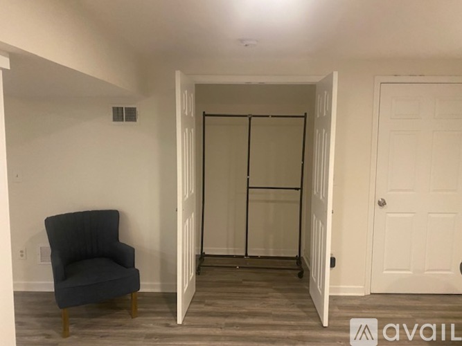 A room with a grey chair and a white door.