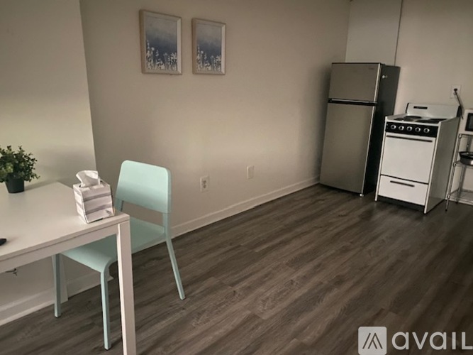 A kitchen with a white table and a green chair.
