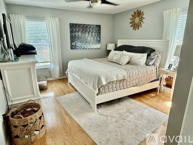 A bedroom with a large bed and a ceiling fan.