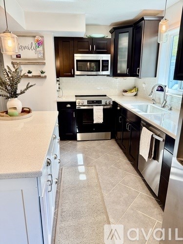 A kitchen with black cabinets and a white countertop.