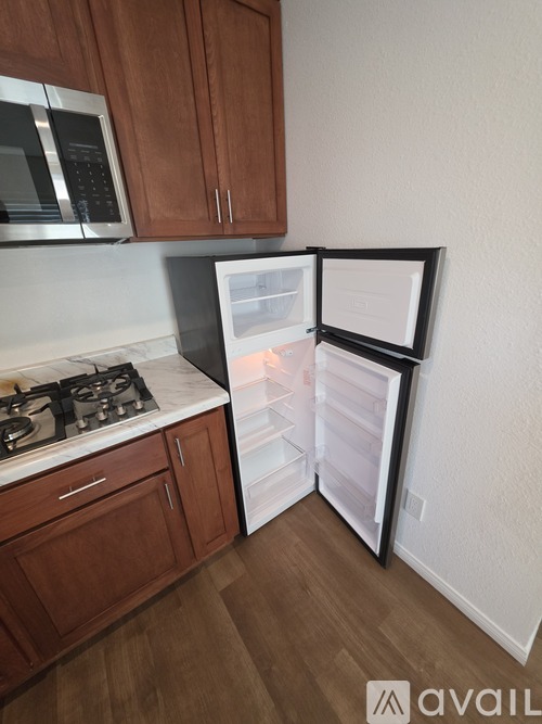 A kitchen with wooden cabinets and a white fridge.