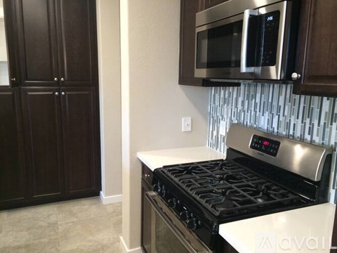 A modern kitchen with a stainless steel stove and microwave above it.