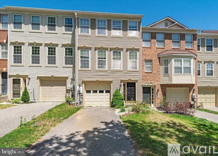 A row of townhouses with garages in front of them.