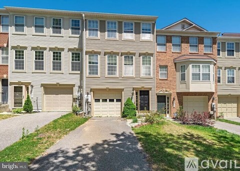 A row of townhouses with garages in front of them.