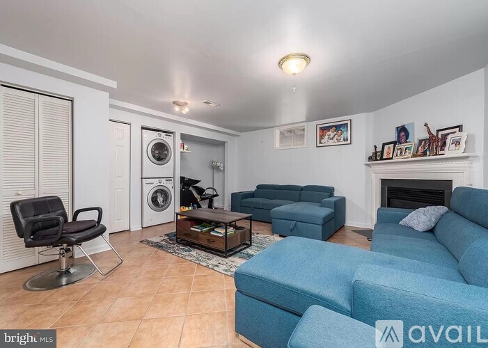 A living room with a blue couch and a fireplace.