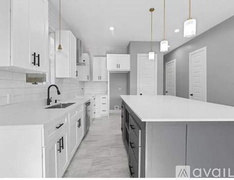 A modern kitchen with white cabinets and a large island.