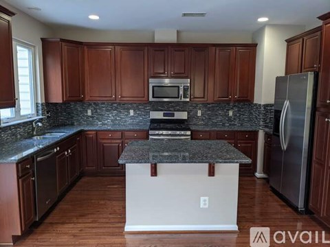 A kitchen with brown cabinets and a granite countertop.
