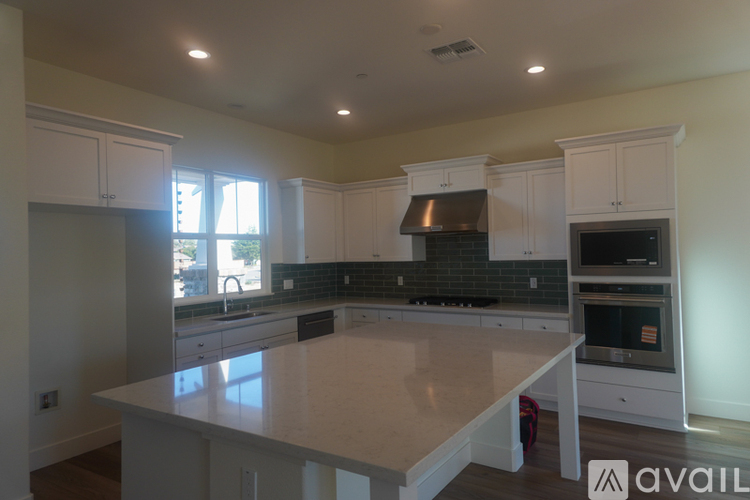 A kitchen with white cabinets and a large island.